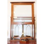 A mid-20th century teak cased set of laboratory scales; together with a cased set of brass