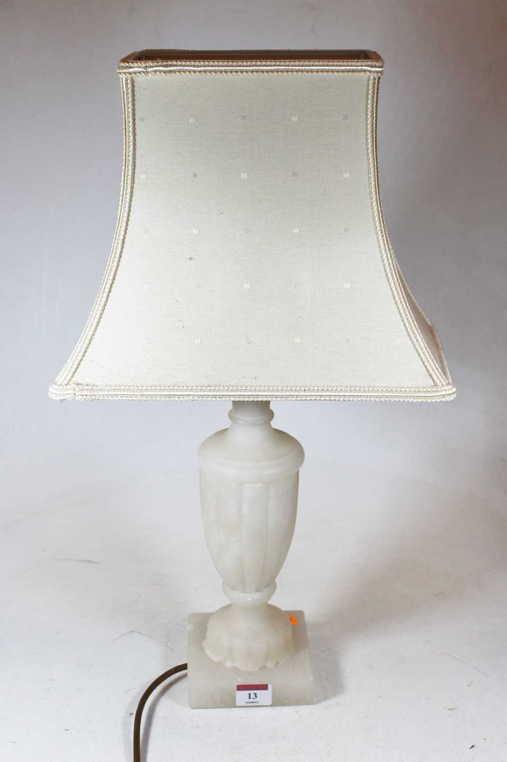 A carved alabaster table lamp, of fluted urn shape, on a square plinth, with shade, h.53cm