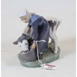 A Royal Copenhagen Danish porcelain model of a lady feeding a calf, on naturalistic base, having