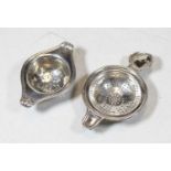 An early 20th century silver tea strainer; together with a white metal example (2)Condition