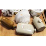 A collection of three stoneware foot-warmers; together with a continental ceramic wall pocket (4)