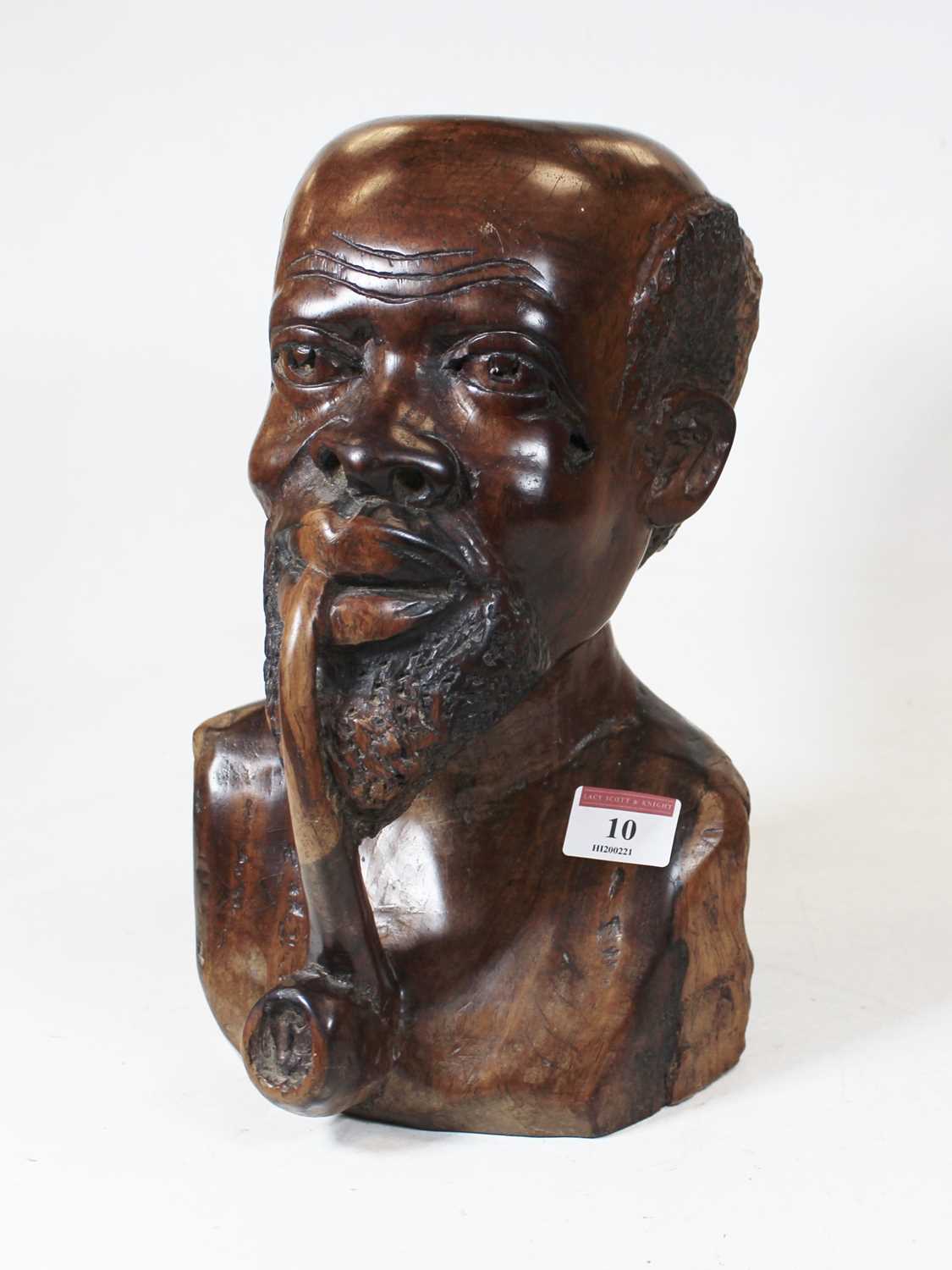 A large carved hardwood head and shoulders portrait bust of a man smoking a pipe, h.27cm