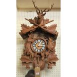 A 20th century Swiss stained and relief carved beech hanging cuckoo clock, surmounted with a stag,