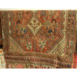 A Turkish woollen rug, the faded ground all-over geometric floral decorated and with tasselled ends,