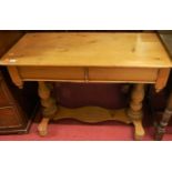 A stained pine round cornered hall table, raised on turned end supports, width 104cm