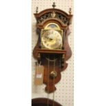 A contemporary Swiss figured walnut hanging wall clock, having a moon-phased arched dial, with two