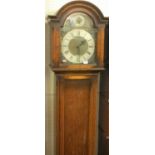 A 1930s oak grandmother clock retailed by Croydon & Sons of Ipswich, the arched dial having