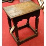 An antique joined oak joint stool, having wavy relief carved frieze, raised on turned and square cut