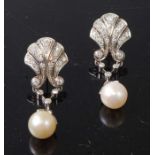 A pair of white metal Art Deco style pearl and diamond earrings, each featuring a 7.8mm pearl