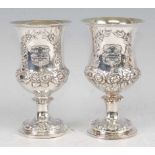 A pair of mid-Victorian silver pedestal goblets, each finely chased with a coat of arms within a