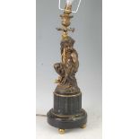 A late Victorian bronze and gilt bronze table lamp, modelled as a cherub holding a branch issuing