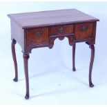 A George II walnut lowboy, having a four quarter veneered feather and crossbanded top, the whole