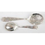 A late Victorian silver serving spoon together with one other matching smaller example, both