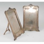 A pair of Mappin & Webb silver easel photograph frames, having shell cast tops, the whole being