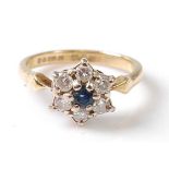 An 18ct yellow and white gold, sapphire and diamond circular cluster ring, featuring a centre