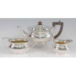 A George V silver three-piece tea-set, comprising teapot, twin handled sugar, and cream, each of