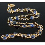 A yellow metal sapphire multi-stone necklet, featuring 42 oval faceted sapphires in bezel