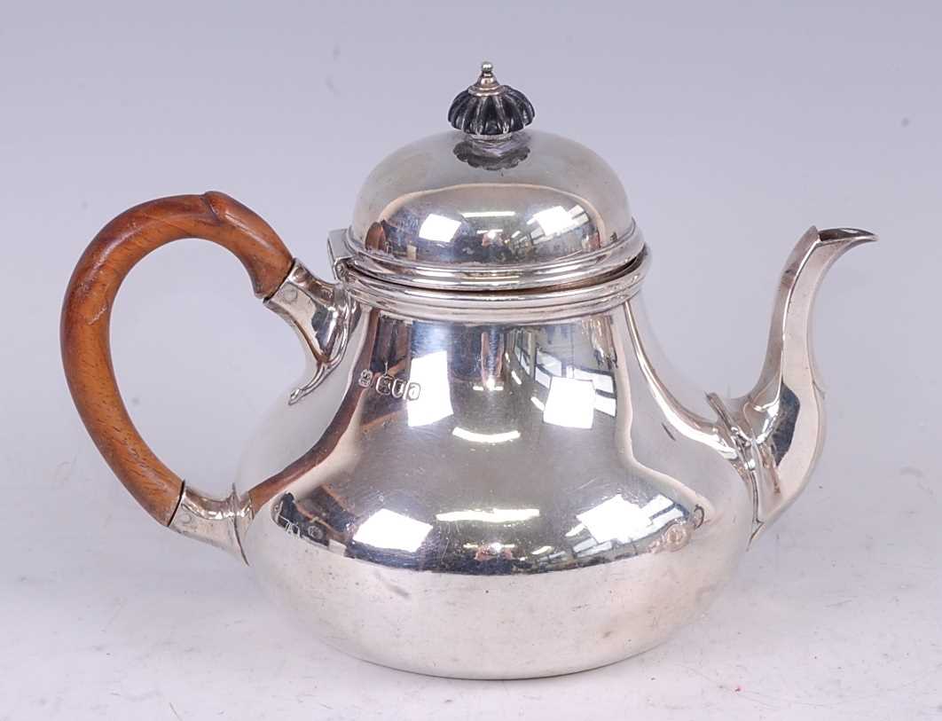 A late Victorian silver teapot, in the early 18th century style, having a hinged domed cover and