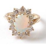 An 18ct yellow and white gold, opal and diamond oval cluster ring, featuring a centre cabochon cut