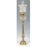 A Victorian brass pedestal oil lamp, having an acid etched shade over cut clear glass font, to a