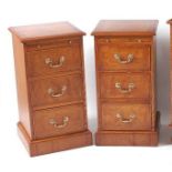 A pair of figured walnut three drawer bedside chests, each having cross and feather banded tops