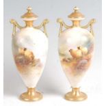 A pair of Royal Worcester porcelain pedestal vases and covers, each of slender baluster form, finely