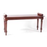 A mahogany window seat, in the Victorian style, having scroll ends and raised on ring turned