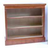 A walnut and figured walnut open bookcase, having a cross and feather banded top over two adjustable