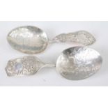 A near-pair of mid-Victorian silver serving spoons, each having bright cut engraved bowls