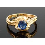 An 18ct yellow gold, sapphire and diamond crossover style dress ring, featuring an oval faceted