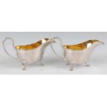 A pair of Mappin & Webb silver sauceboats, each having gilt-washed interiors, reeded edges, and on