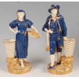 A pair of Worcester porcelain figures of grape-pickers, modelled by James Hadley, each in standing