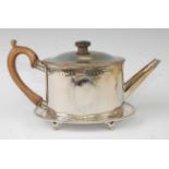 A George III silver teapot on stand, of beaded oval form, both with bright cut engraved