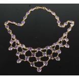 A yellow metal amethyst multi-stone fringe necklet, comprising 47 oval faceted amethysts in bezel