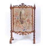 A Victorian rosewood and woolwork inset fire screen, the panel depicting an owl upon a branch amidst