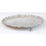 A modern silver salver, having a raised piecrust rim and on scroll feet, the central ground with