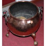 An early 20th century copper coal bin of squat circular form having wrought iron ring handles,