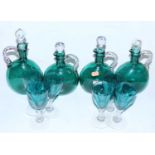 A set of four Victorian green glass decanters and stoppers, each having rope twist handle (