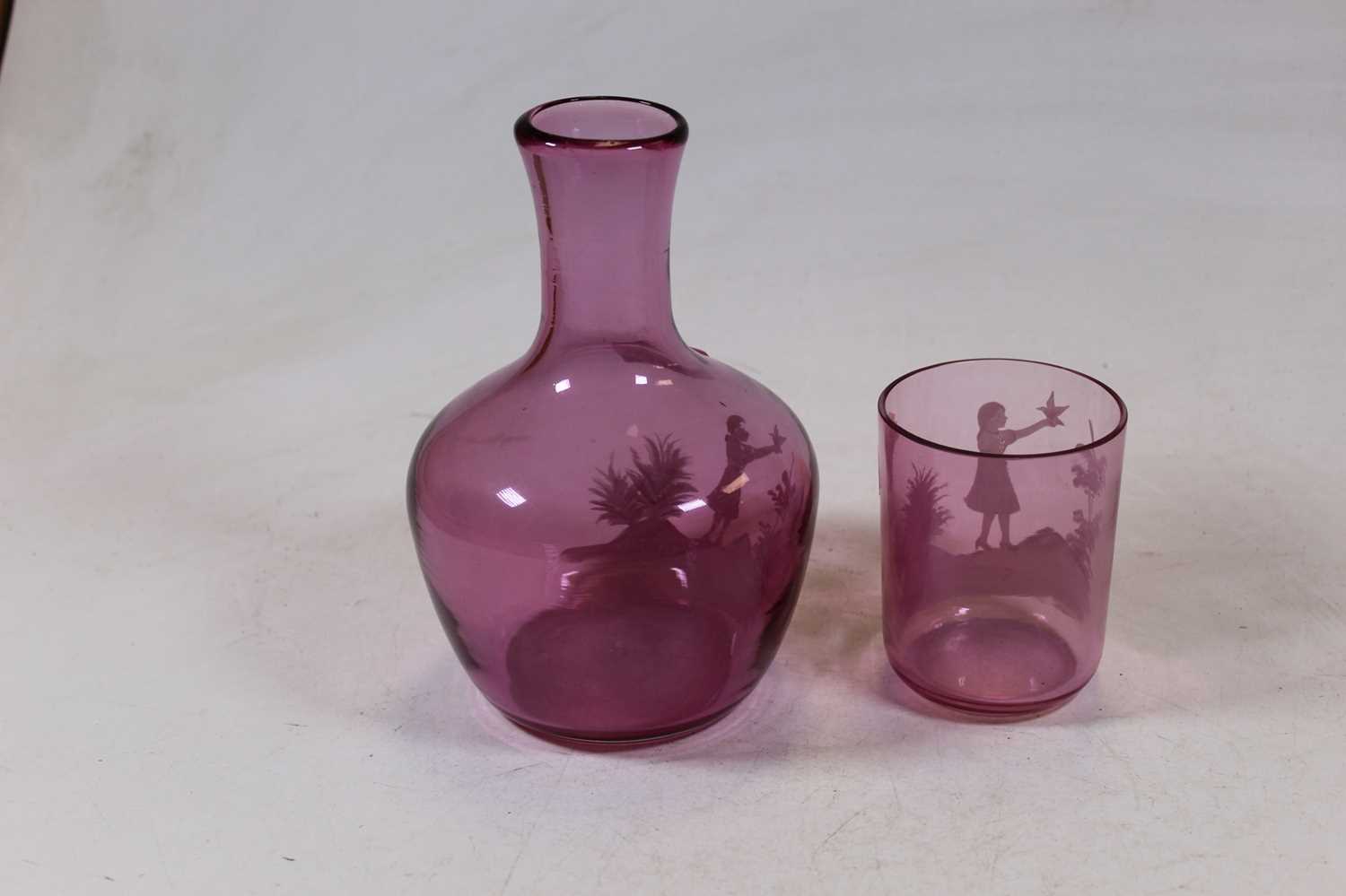 An amethyst tinted glass carafe with Mary Gregory style decoration in the form of a girl with bird - Image 2 of 5