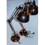 A pair of copper effect angle poise desk lamps