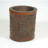 A modern Chinese style brush-pot, carved with various figures within a woodland landscape, h.16cm