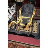 A late Victorian wooden and wicker pram, having single black upholstered seat, the whole on
