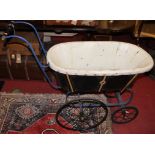 A Victorian iron framed pram, having black leather coachwork with painted detail, white fabric lined