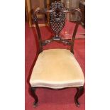 A pair of late Victorian floral carved mahogany salon side chairs, together with a matching pair