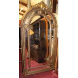 An extremely large arched floral gilt framed and bevelled floor mirror (long running horizontal