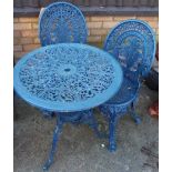 A blue painted, pierced and floral decorated metal circular garden table, dia. 68.5cm, with pair