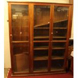 A large stained pine three door glazed shop cabinet, w.172cm
