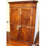 A 19th century mahogany and flame mahogany twin panelled double door hanging corner cupboard, height