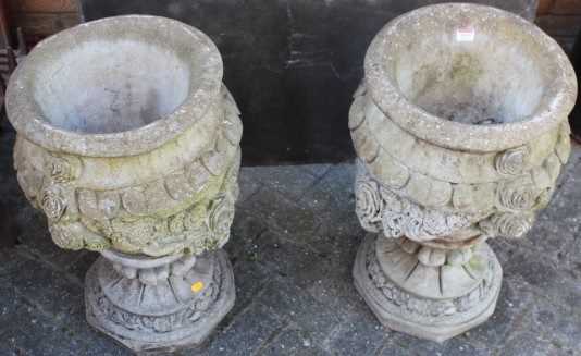 A pair of reconstituted stone circular pedestal garden urns, with floral swag decoration, height