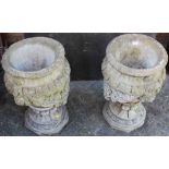A pair of reconstituted stone circular pedestal garden urns, with floral swag decoration, height
